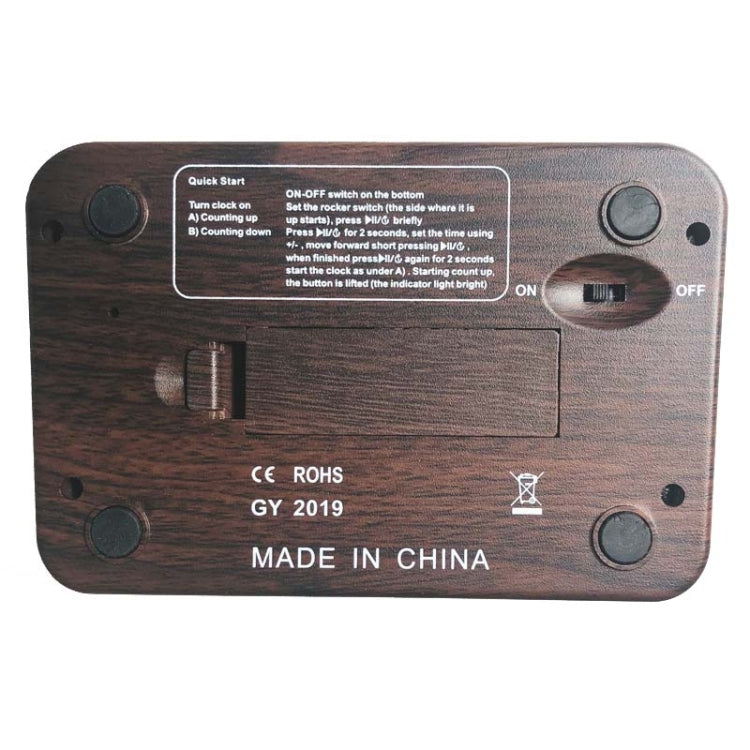 Wood-grain digital chess clock back panel with buttons and compliance labels