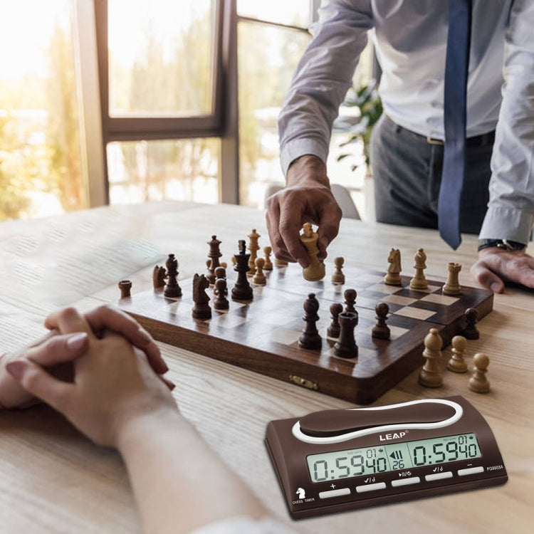 LEAP digital chess timer on a tabletop with dual LCDs during a board game