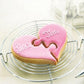 Heart-shaped pink biscuit with puzzle-style cutout on top