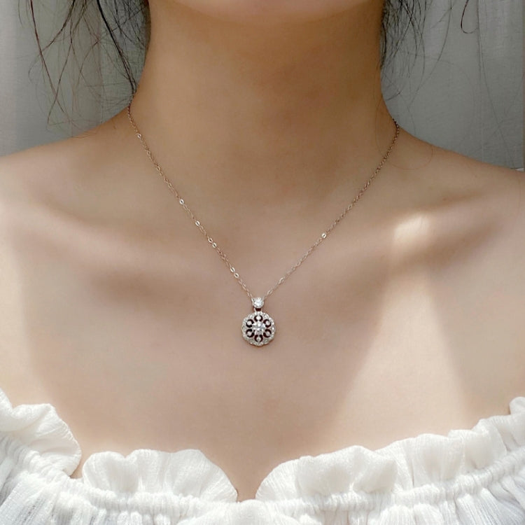 Silver moissanite-style flower pendant necklace worn on a neckline