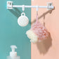 White telescopic rod with ring hooks holding hanging bath loofah sponges