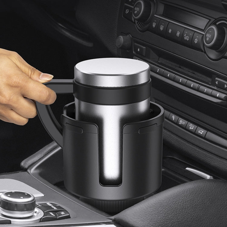 Installed car cup holder and storage box with silver lid, black body, hand pushing in
