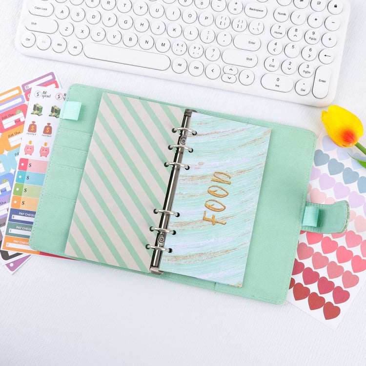 Mint green crocodile-pattern loose-leaf binder open with planner tabs