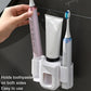 Wall-mounted toothpaste squeezer unit with side toothbrush holders and tube squeezing cradle