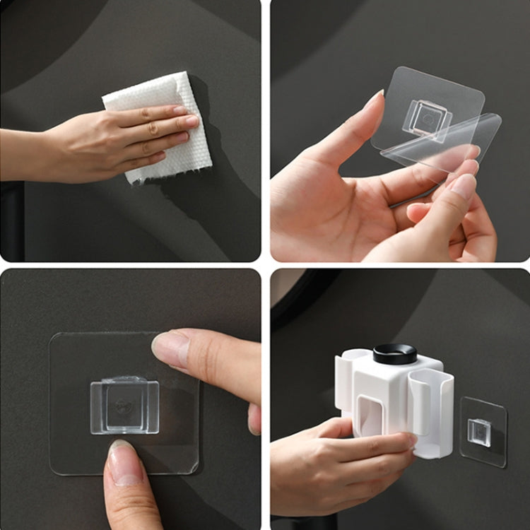 Hands applying clear adhesive mount for a white wall toothpaste squeezer holder