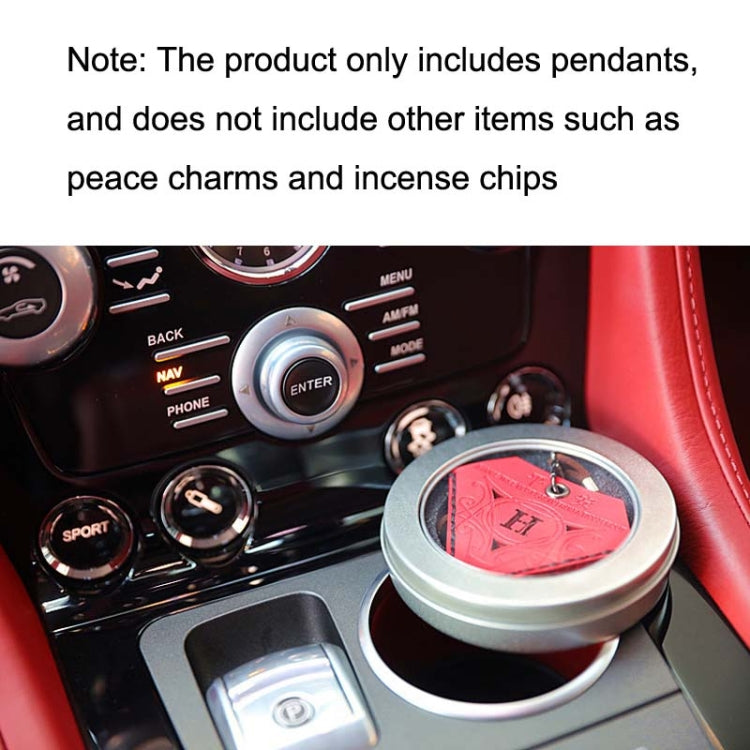 Red triangular leather charm on car dashboard near round accessory box