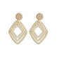 Bamboo vine woven earrings with textured gold cap and cream V-shaped drop, gold hook