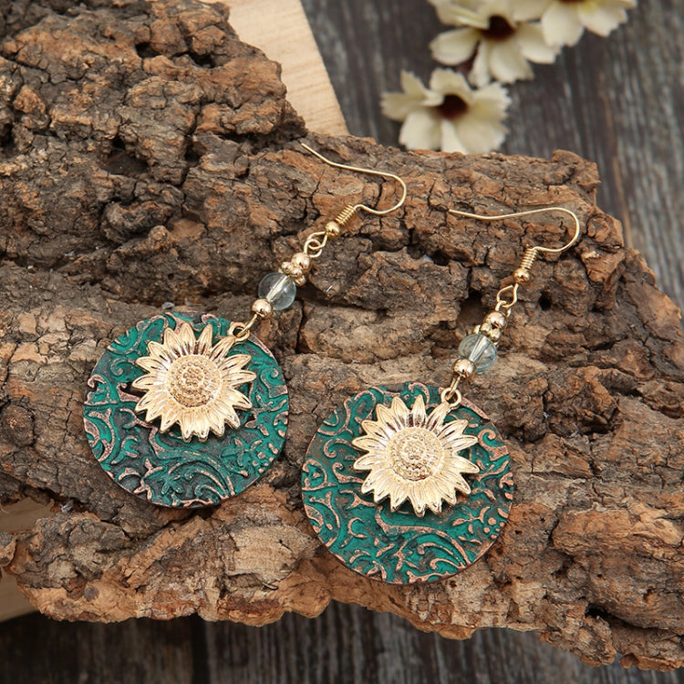 Sunflower dangle earrings with teal patterned discs, gold flower medallions, and crystal beads