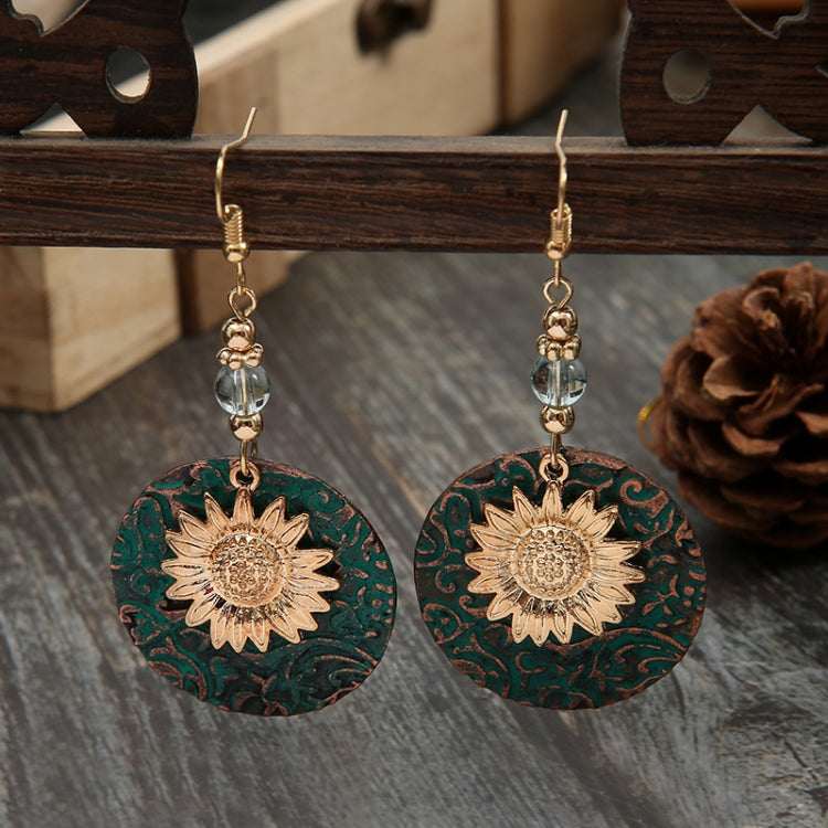 Sunflower drop earrings with teal discs, gold sunflower center, and faceted crystal dangles