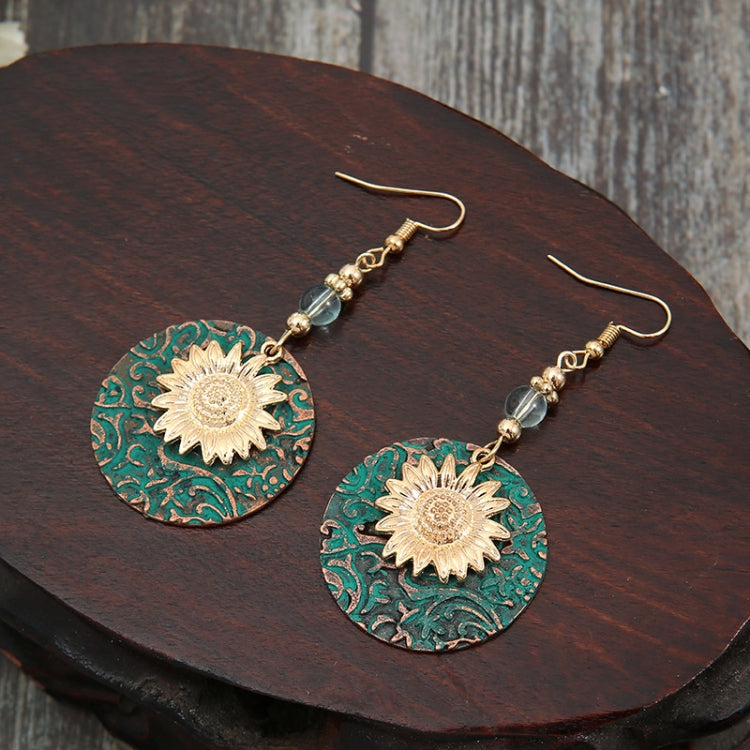 Sunflower drop earrings with teal patterned round discs, gold flower centers, and beaded drops