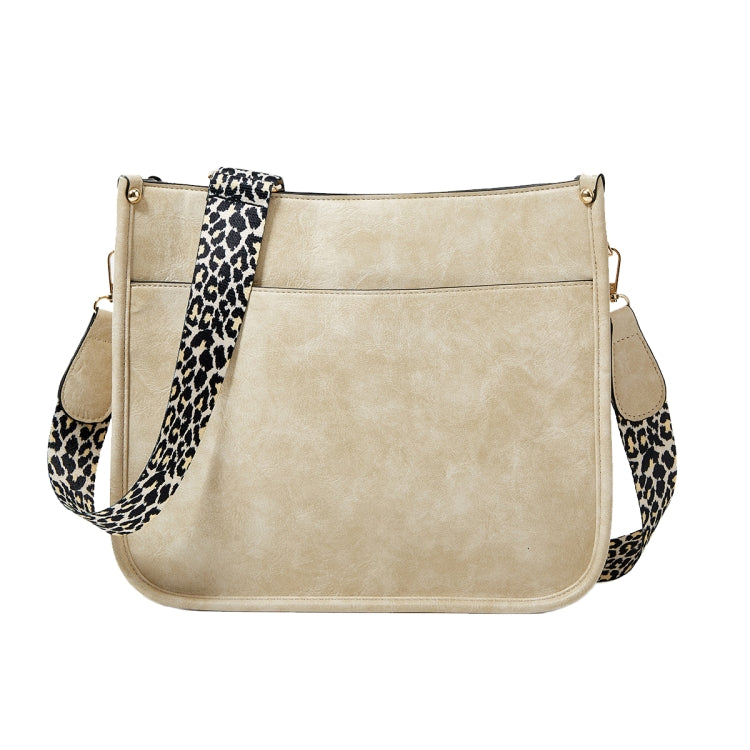 Beige PU leather crossbody tote bag with leopard-print strap and front panel seams