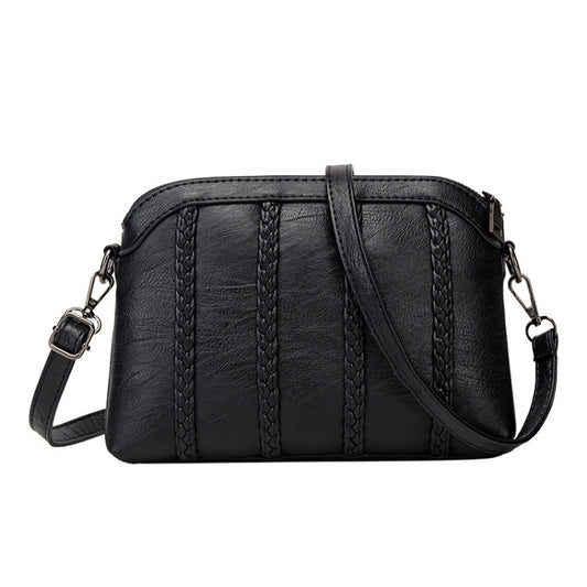 Black crossbody handbag with top zipper, braided front panels, and adjustable shoulder strap