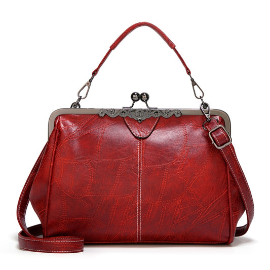 Red vintage-style leather crossbody bag with buckle clasp and adjustable strap.