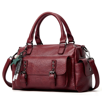 Claret pebbled leather handbag with top handles, crossbody strap, and front flap pocket