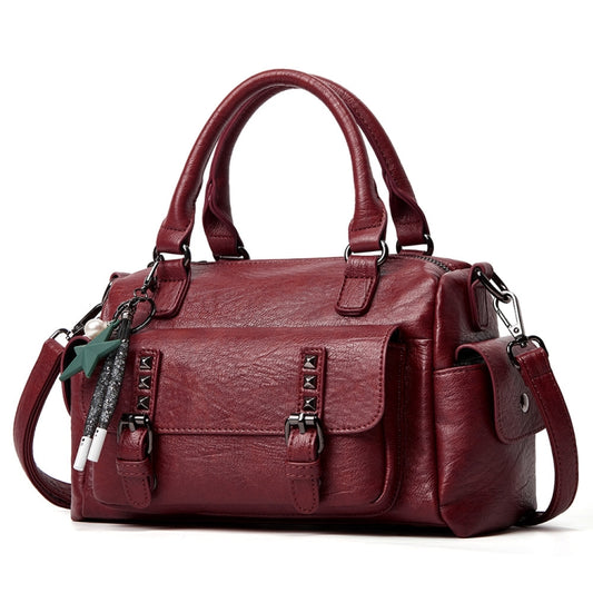 Claret pebbled leather handbag with top handles, crossbody strap, and front flap pocket
