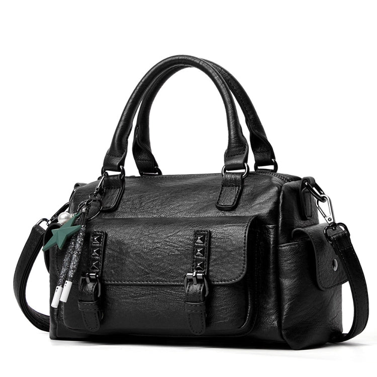 Black pebbled leather handbag with top handles, crossbody strap, and front flap pocket