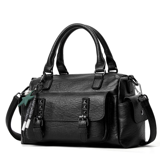 Black pebbled leather handbag with top handles, crossbody strap, and front flap pocket