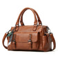 Brown pebbled leather handbag with top handles, crossbody strap, and front flap pocket