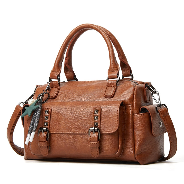 Brown pebbled leather handbag with top handles, crossbody strap, and front flap pocket