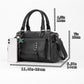 Black pebbled leather handbag with crossbody strap and front flap pocket, beside smartphone