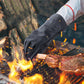 Grey flame-resistant BBQ gloves with insulated fingers near open fire and sparks