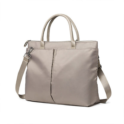 Light khaki laptop tote with top handles, shoulder strap, and front buckle pocket