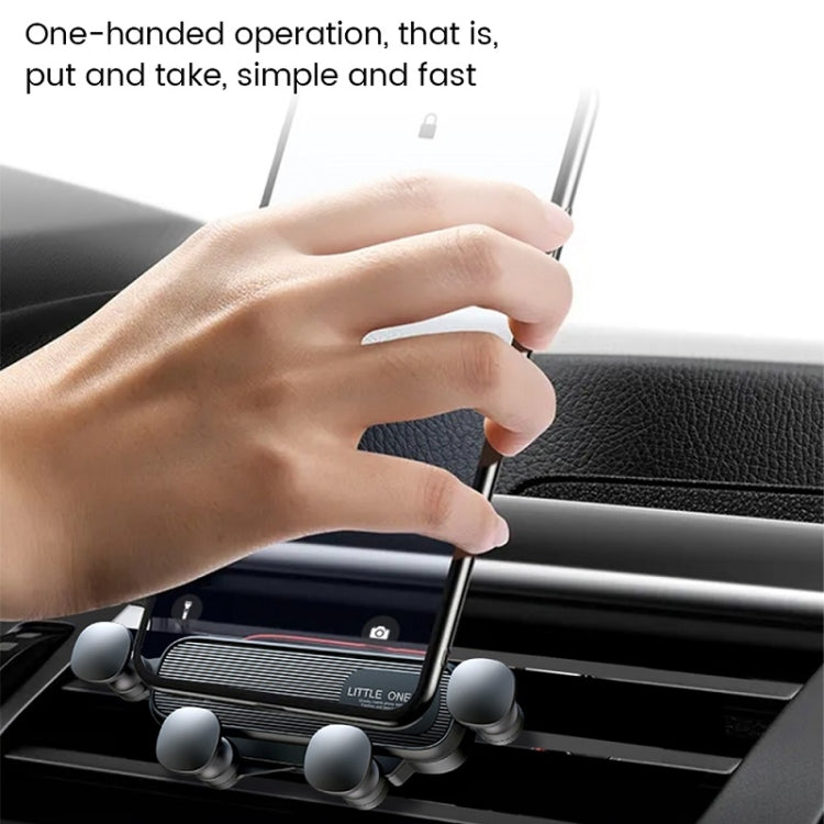 Gravity air-vent phone holder being adjusted by a hand on a car dashboard