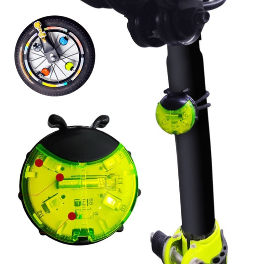 Green ladybug-style wheel hub light on a black bicycle fork