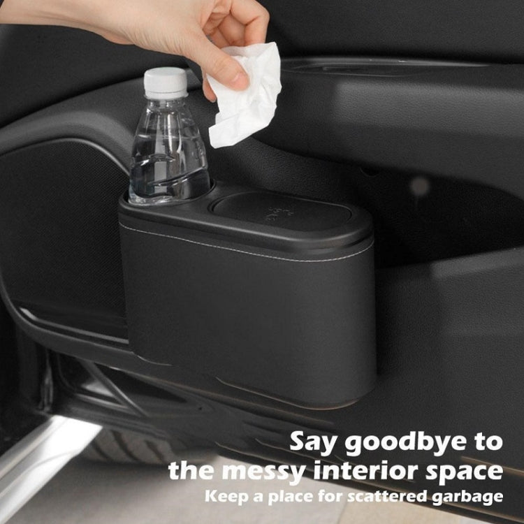 Car seat cup holder trash bin, black plastic with cup opening and bottle being cleaned