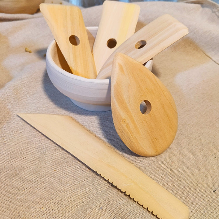Light wood pottery scraper set in a bowl, long blade with serrated edge