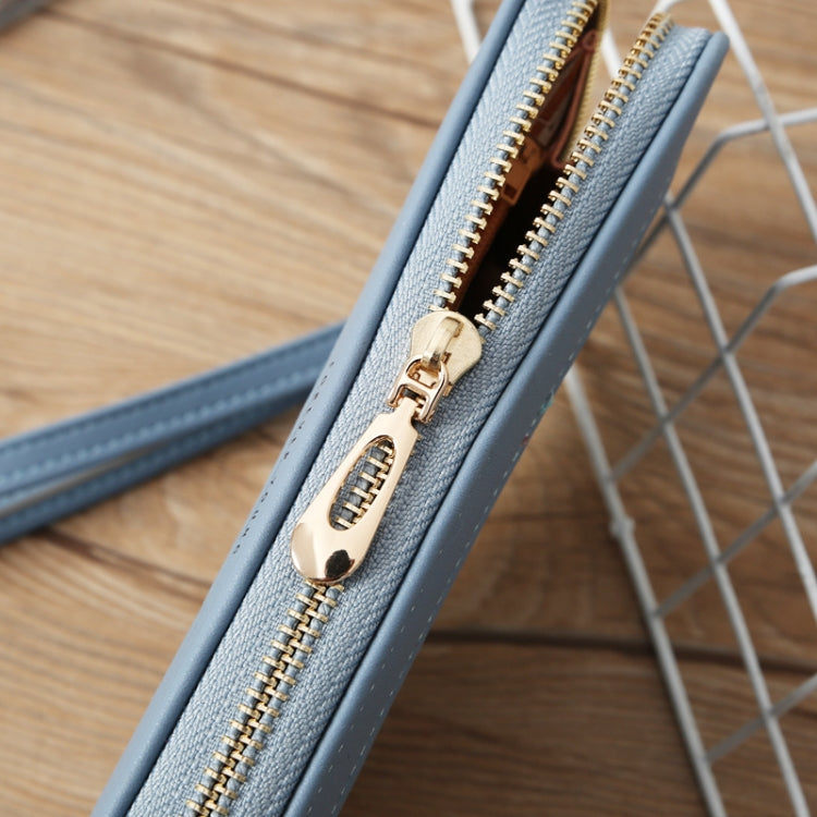 Light blue wallet close-up: gold-tone zipper pull on crocodile-embossed surface