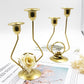 Pair of gold-tone double candle holders with rose accents on tabletop