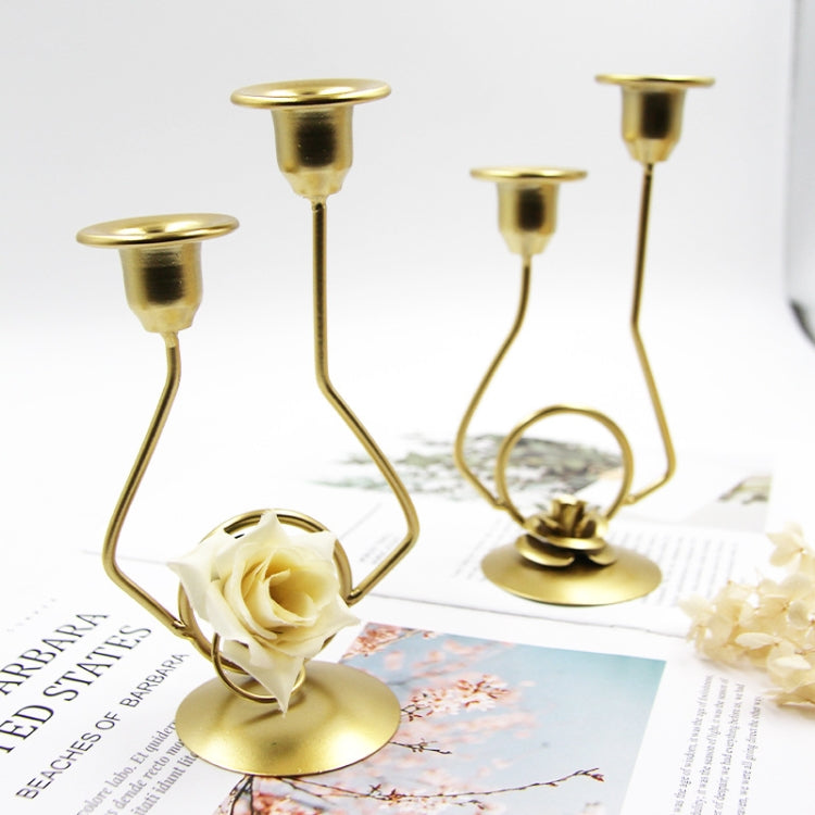 Pair of gold-tone double candle holders with rose accents on tabletop