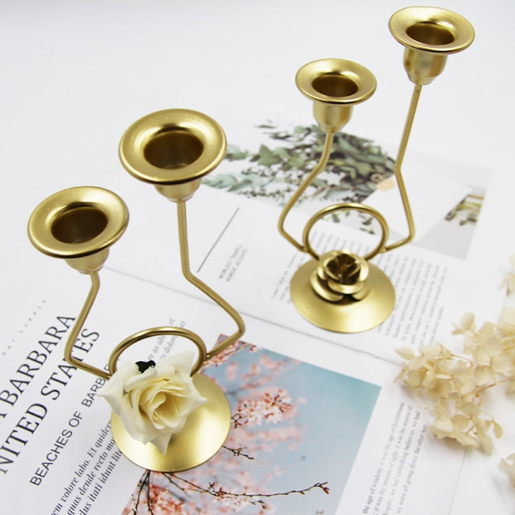 Gold-tone candle holder set with white rose accents on wedding invitation paper