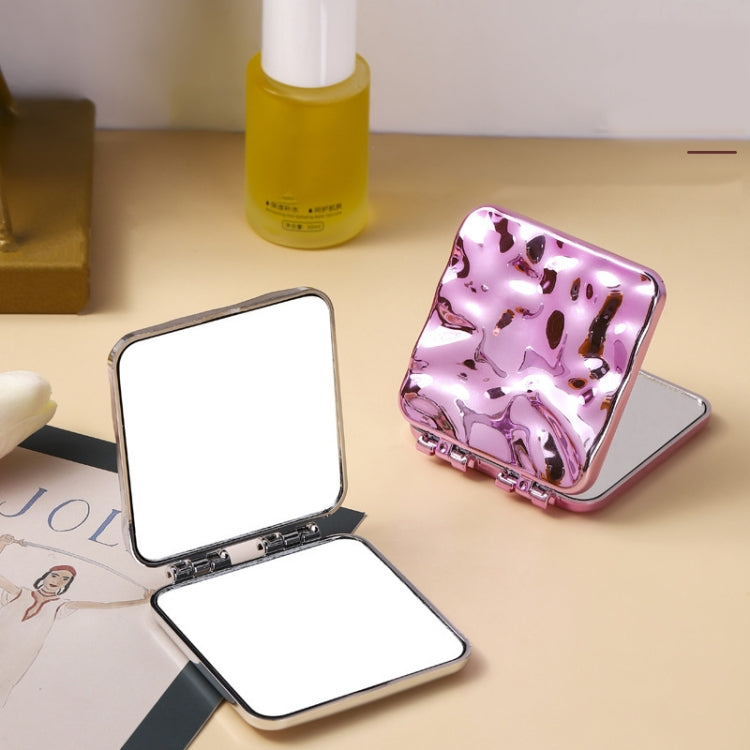 Folding compact double-sided makeup mirror open with purple back and white reflective panels