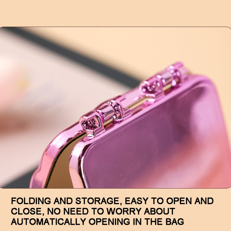 Purple folding compact mirror close-up with metal clasp and hinge, glossy electroplated finish
