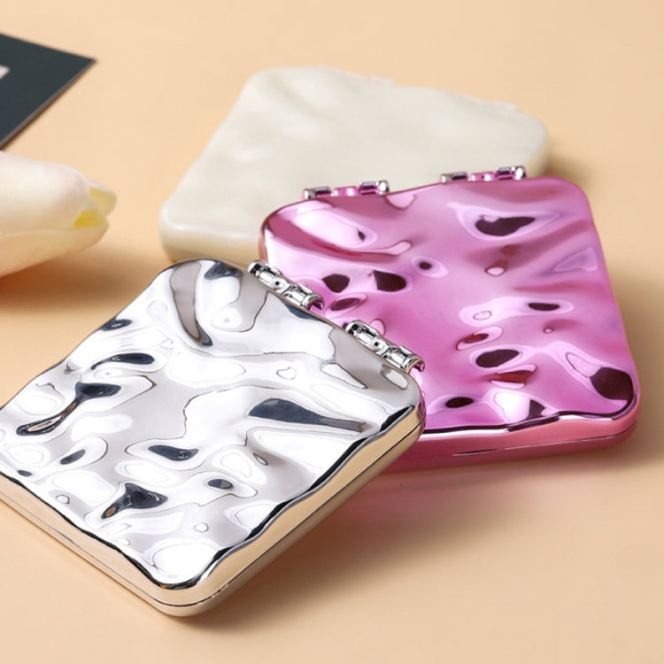 Folding compact double-sided makeup mirrors in purple and silver, with beige mirror behind