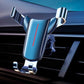 Blue triangular gravity phone holder clipped to car air vent, chrome arms and base supports