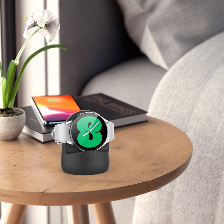 Black silicone charging stand with watch cradle on bedside table