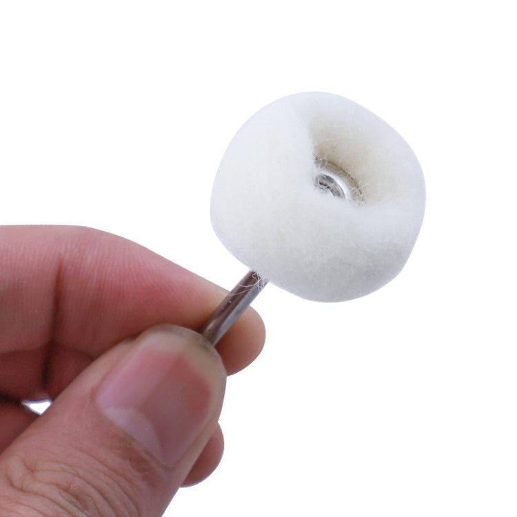 White wool polishing wheel on a metal stem, held by a hand