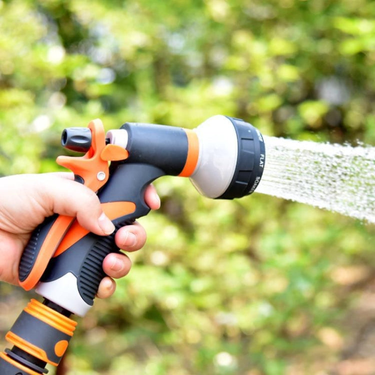 Handheld orange and black garden watering sprinkler spraying a fine water stream