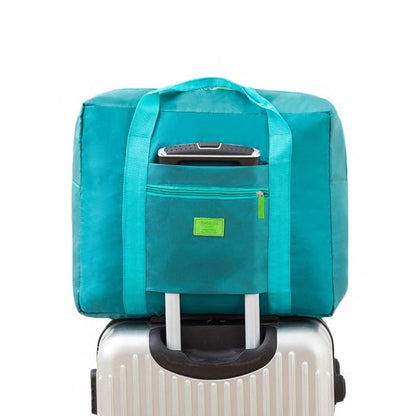 Turquoise trolley storage bag with front panel pocket and top handle, fits over luggage handle