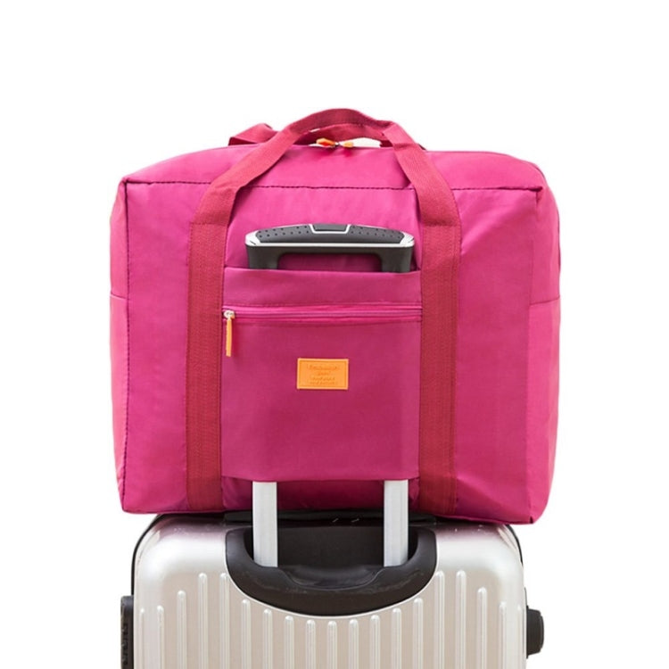 Pink trolley storage bag with front zip pocket and top handle, designed to slide over luggage