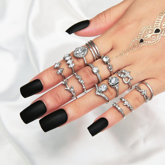 Silver-tone stackable rings with heart and water-drop rhinestone details on hand