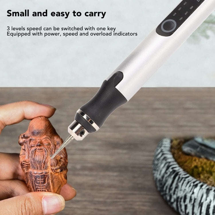 Rose gold mini drill pen held by hand with metal engraving tip on wood
