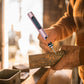 Rose gold mini electric drill pen in hand with metal tip carving a wooden block
