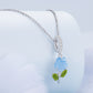 Sterling silver necklace with blue color-changing rose charm and green enamel leaves