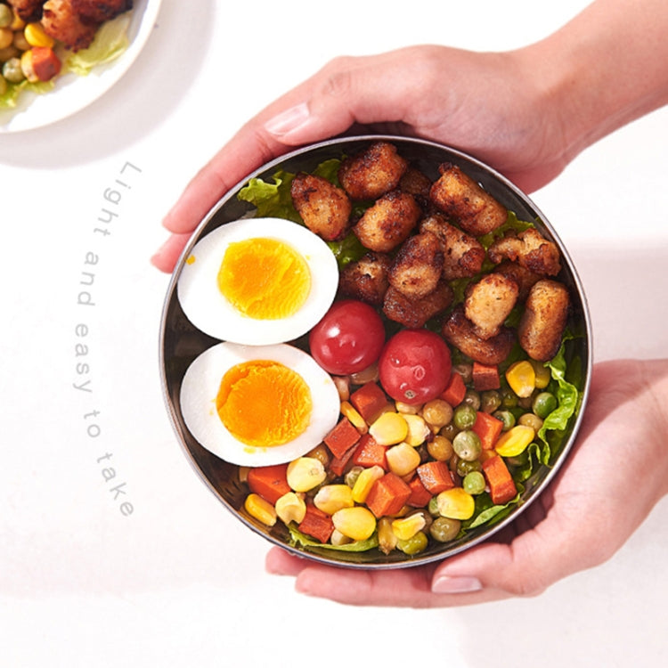 Kids double-layer stainless steel bowl filled with meal, held by hands with lid off