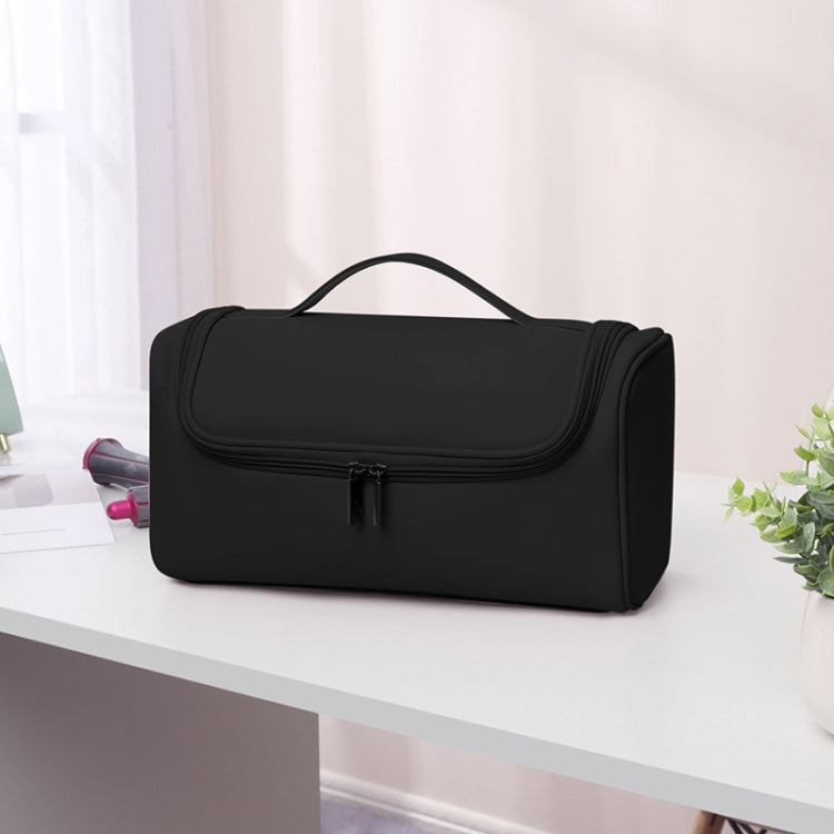 Black storage bag with curved handle and front flap zip closure