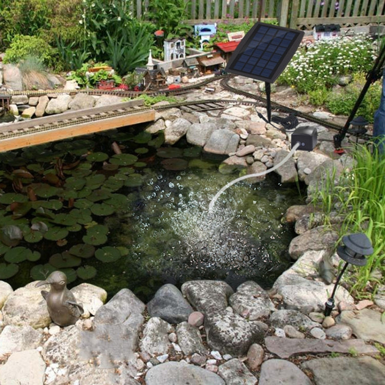 Solar aeration pump with solar panel over pond, producing water bubbling near rocks